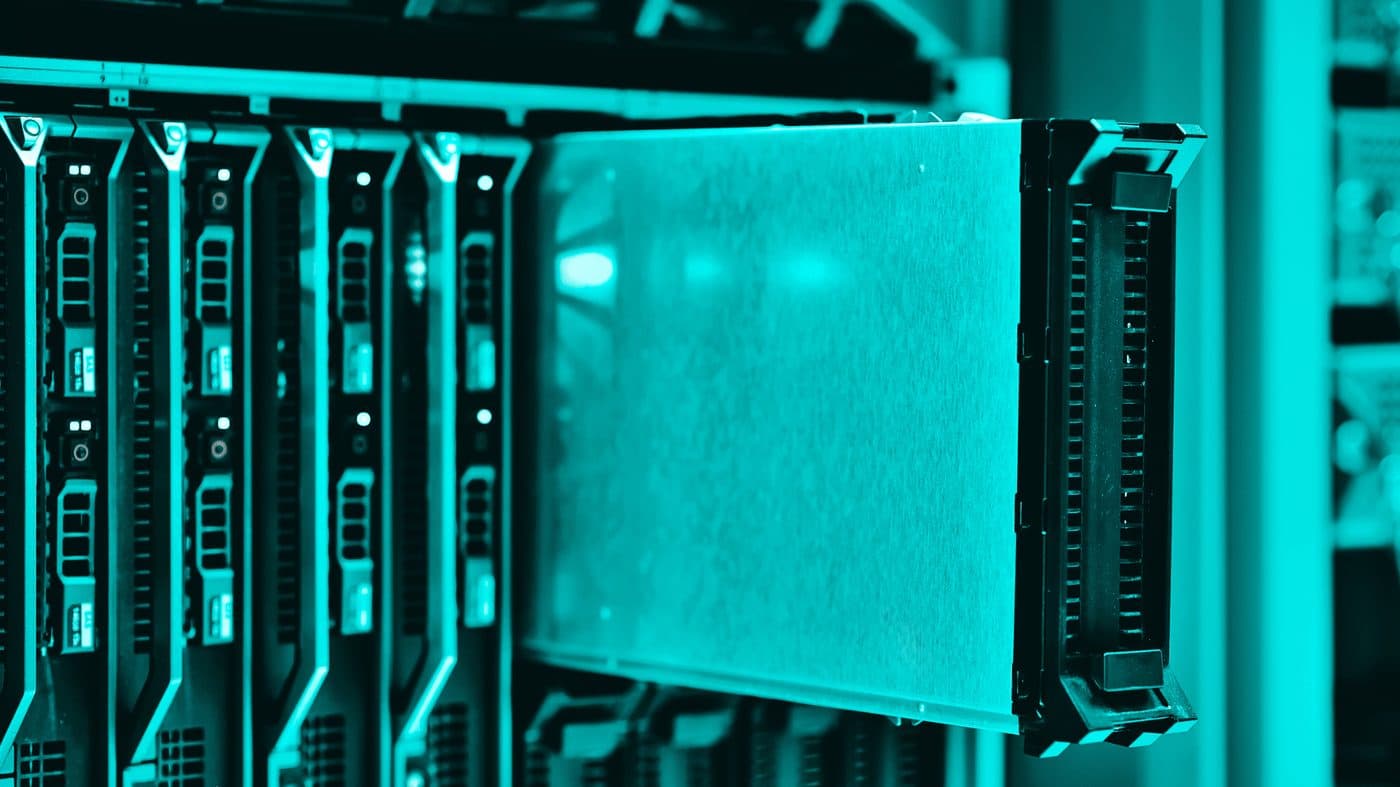 Rows of data-centre server racks lit in teal