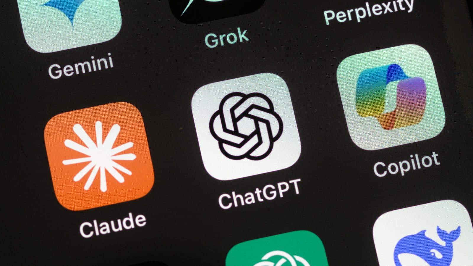 Close-up of a phone screen showing the Claude, ChatGPT, Gemini, Grok and Copilot app icons