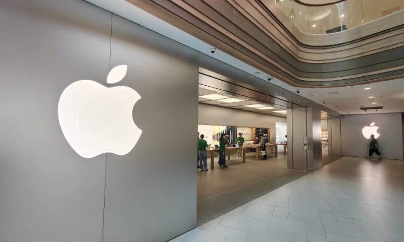 벽에 조명으로 비친 Apple 로고가 설치된 Apple Store 내부