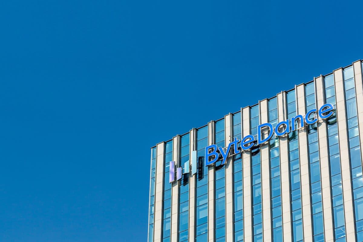 The ByteDance name and logo mounted near the top of a glass office building against a clear blue sky.