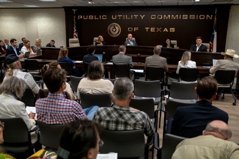 Un’udienza pubblica della Public Utility Commission of Texas, vista dal fondo di una sala piena.