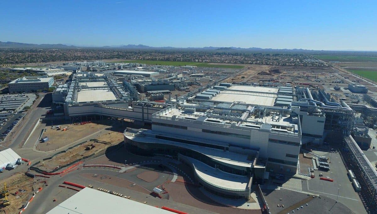 Aerial view of a large Intel semiconductor manufacturing campus, with fab buildings and construction ground stretching to the horizon.