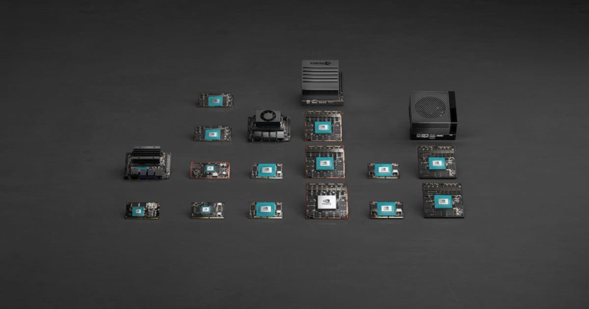 Vista de cima de vários módulos Nvidia Jetson pequenos e placas carrier dispostos sobre uma superfície escura