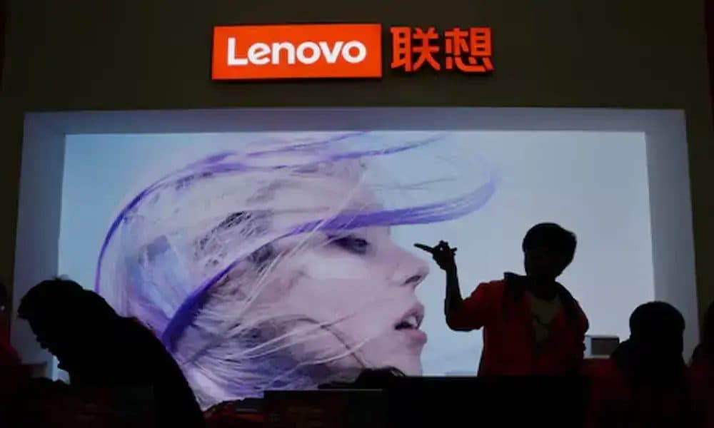 행사장에서 Lenovo 브랜드 대형 디스플레이 화면 앞에 방문객들이 실루엣으로 서 있는 모습.