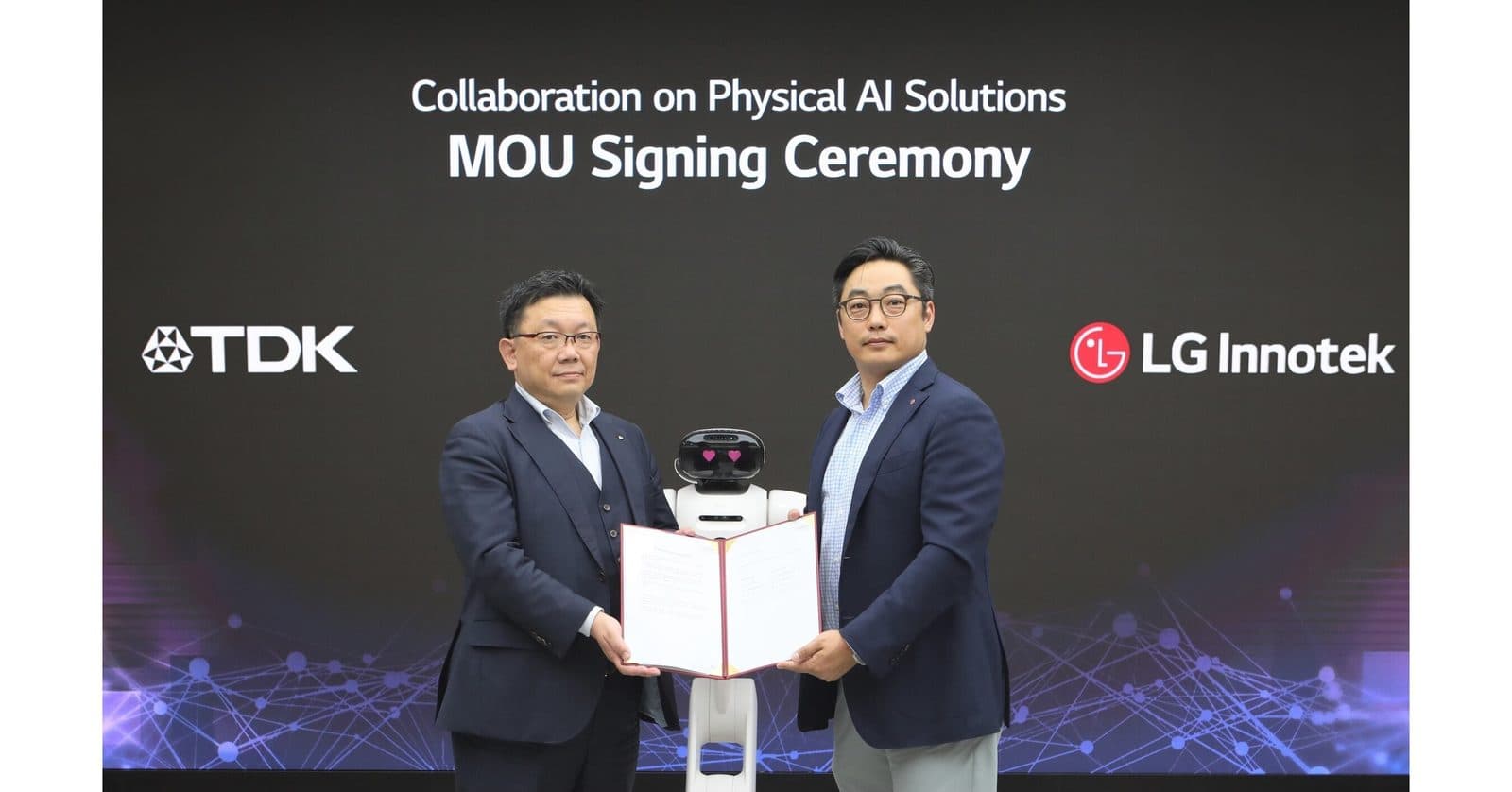 مصافحان من التنفيذيين فوق وثيقة موقعة خلال مراسم مذكرة التفاهم، تحت لافتة تحمل عبارة 'Collaboration on Physical AI Solutions' مع شعاري TDK وLG Innotek