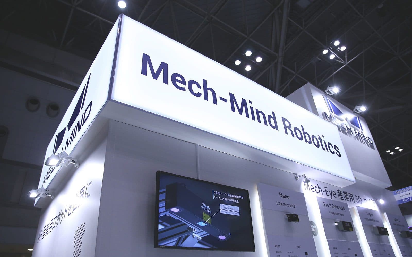 Lo stand espositivo di Mech-Mind Robotics a una fiera, con il nome dell'azienda sulla fascia superiore e i prodotti esposti sotto
