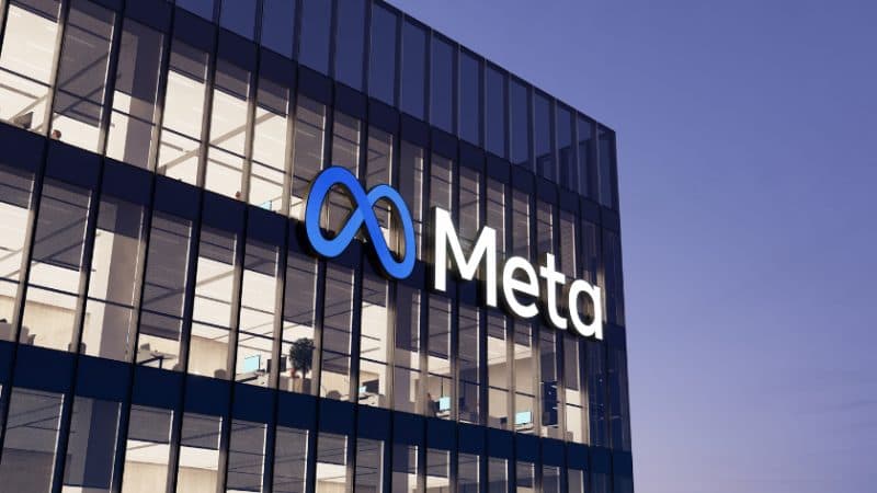 The Meta logo and wordmark on the glass facade of a company building