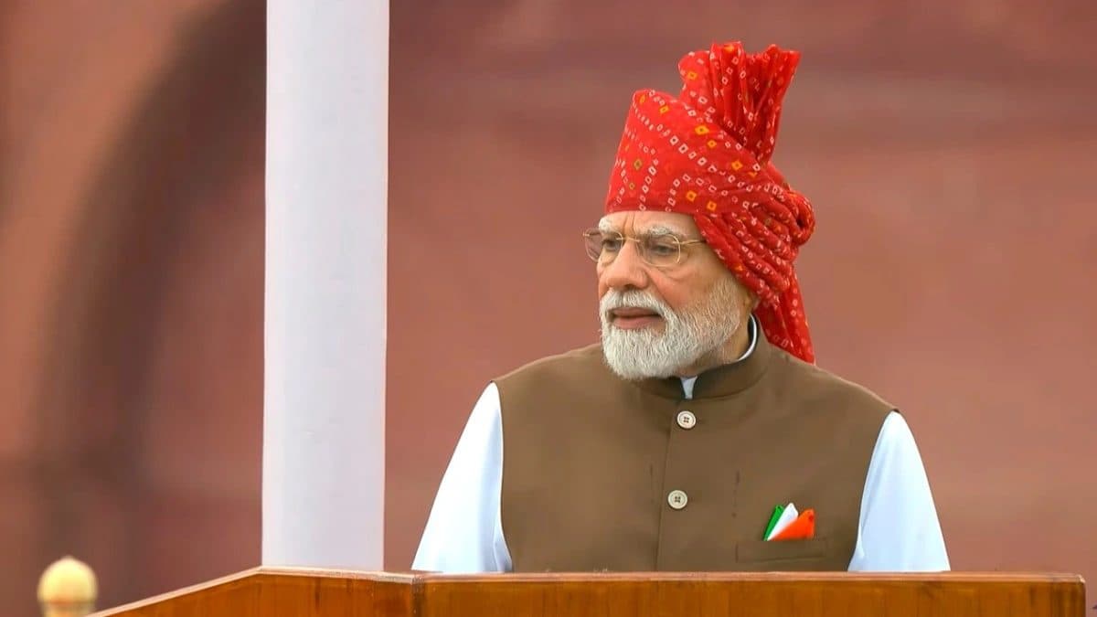 Narendra Modi prononçant un discours depuis une tribune, coiffé d’un turban rouge.
