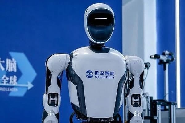Un robot umanoide bianco con il logo Motion Brain sul petto, fotografato in uno stand espositivo