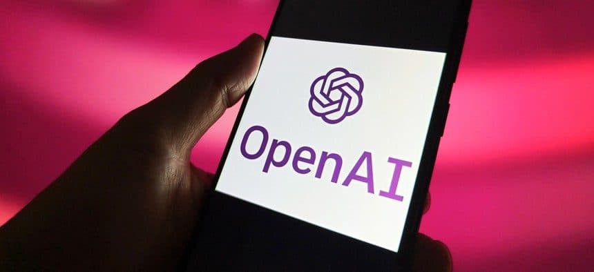 A hand holding a phone displaying the OpenAI logo against a magenta background