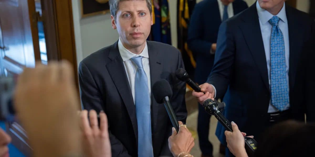 나무 패널로 마감된 복도에서 기자들 마이크 여러 개를 마주한 OpenAI 최고경영자 Sam Altman