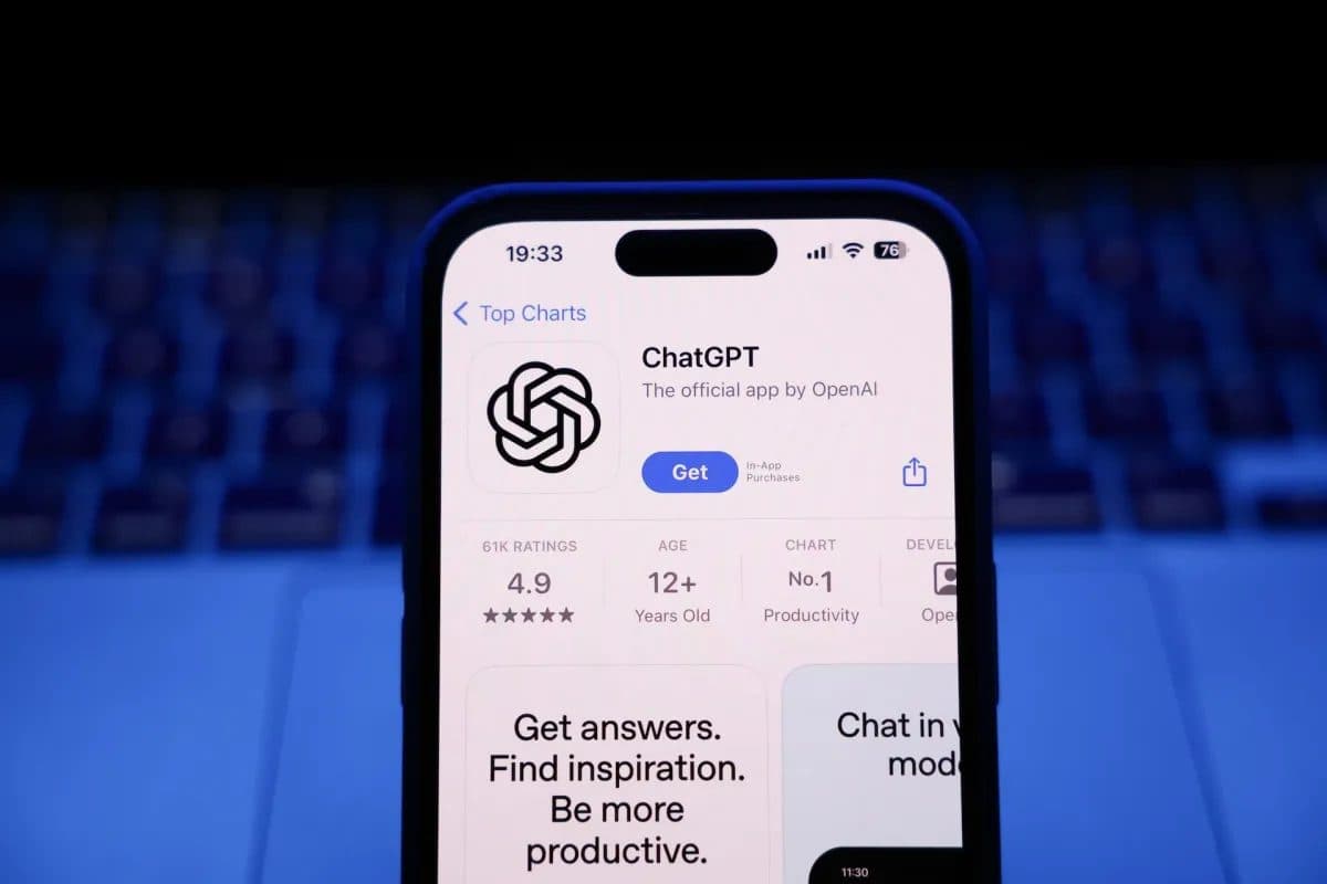 An iPhone showing the ChatGPT listing in the App Store Top Charts, rated 4.9 and ranked No. 1 in Productivity
