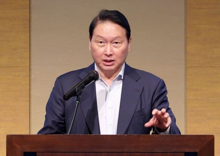 단상 마이크 앞에서 연설하며 한 손을 들어 제스처를 하는 SK 그룹 최태원 회장