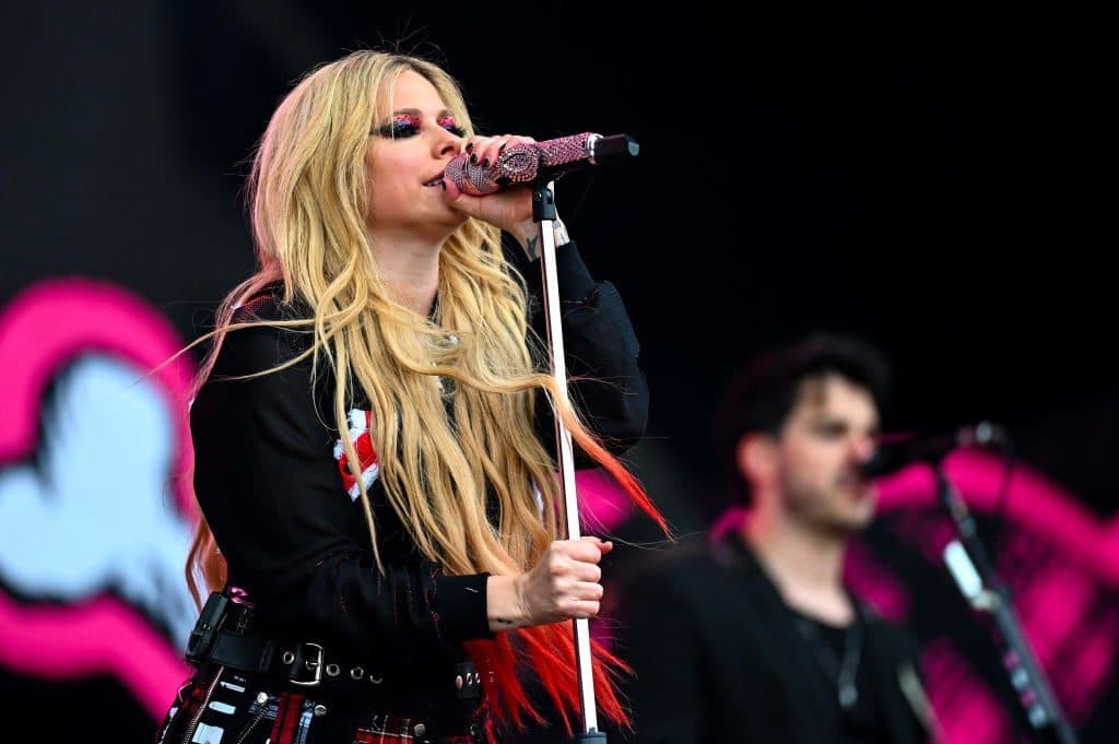 Avril Lavigne singing into a microphone on stage; her song “Sk8er Boi” is among the works cited in SOCAN's claim.