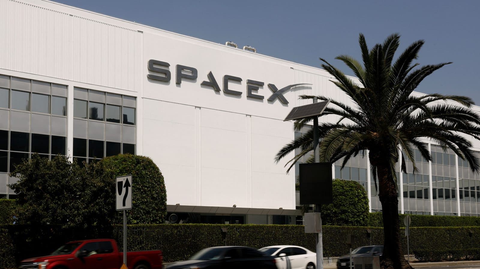 L'edificio della sede di SpaceX con palme e un parcheggio davanti