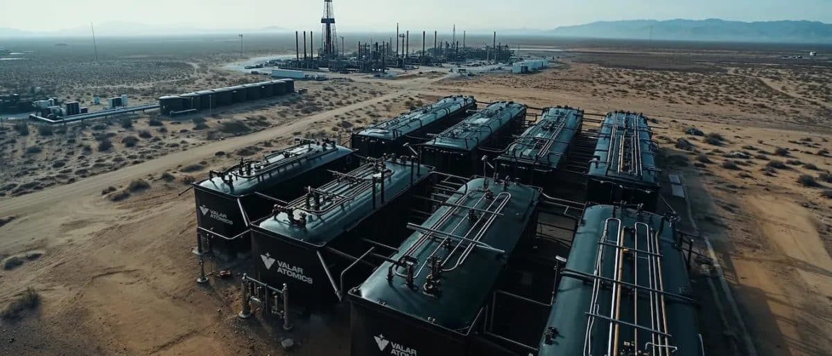 Aerial view of a desert industrial site with rows of modular units and pipework stretching toward the horizon.