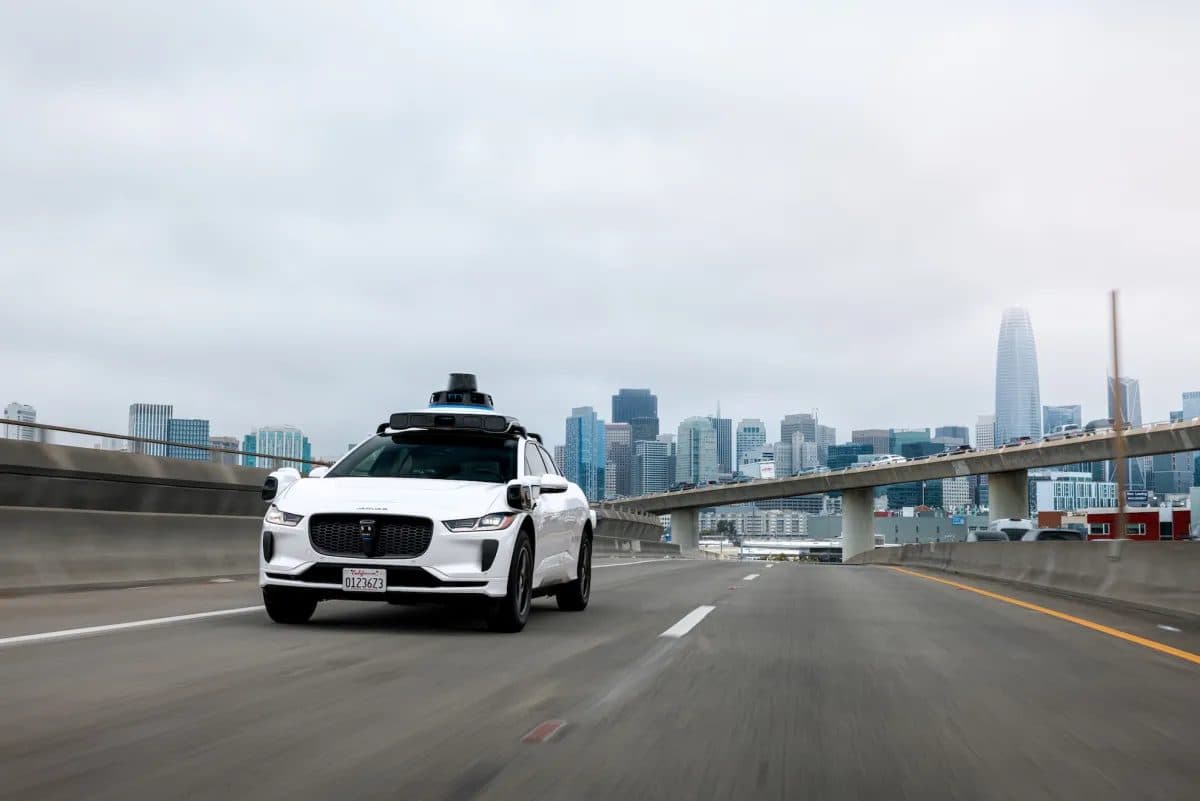 A Waymo robotaxi driving on a freeway.